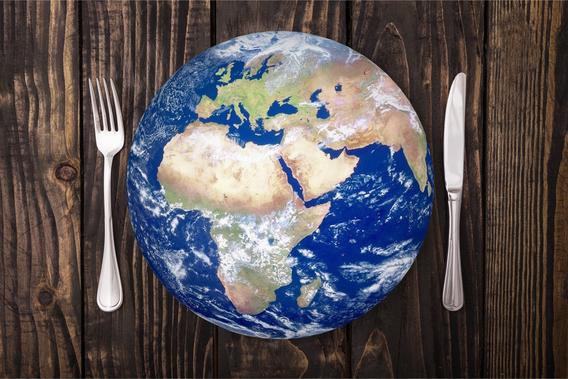 Planet earth as a dinner plate, with a fork and knife